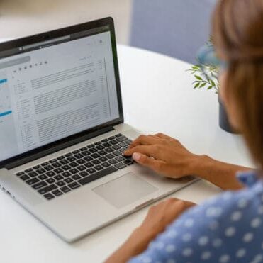 Latin American woman working at home and reading e-mails on her laptop computer - lockdown concepts